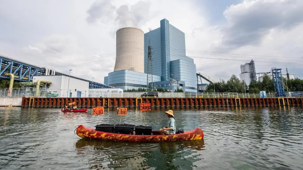 Ein-Klimaaktivist-paddelt-mit-seinem-Kanu-welches-Symbolisch-mit-Kohle-aus-Kolumbien-und-Russland-bestueckt-ist-auf-dem-Dortmund-Ems-Kanal-vor-dem-Steinkohlekraftwerk-Datteln-4-im-Rahmen-eines-Aktions-und-Protesttages