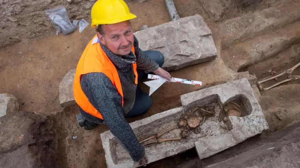 Archaeologe-Felix-Biermann-untersucht-einen-Sarkophag-auf-dem-Gelaende-der-einstigen-Koenigspfalz-Helfta