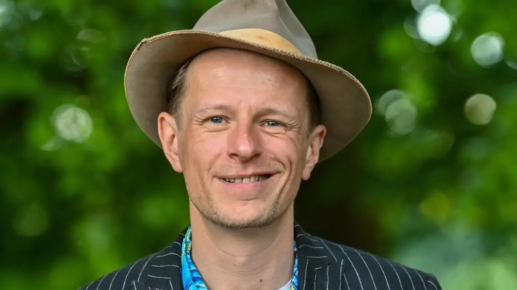 Alexander-Scheer-Schauspieler-Musiker-Saenger-laechelt-in-die-Kamera