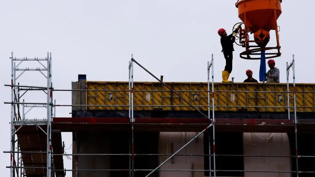 Arbeiter-stehen-auf-einer-Baustelle-eines-Wohngebaeudes