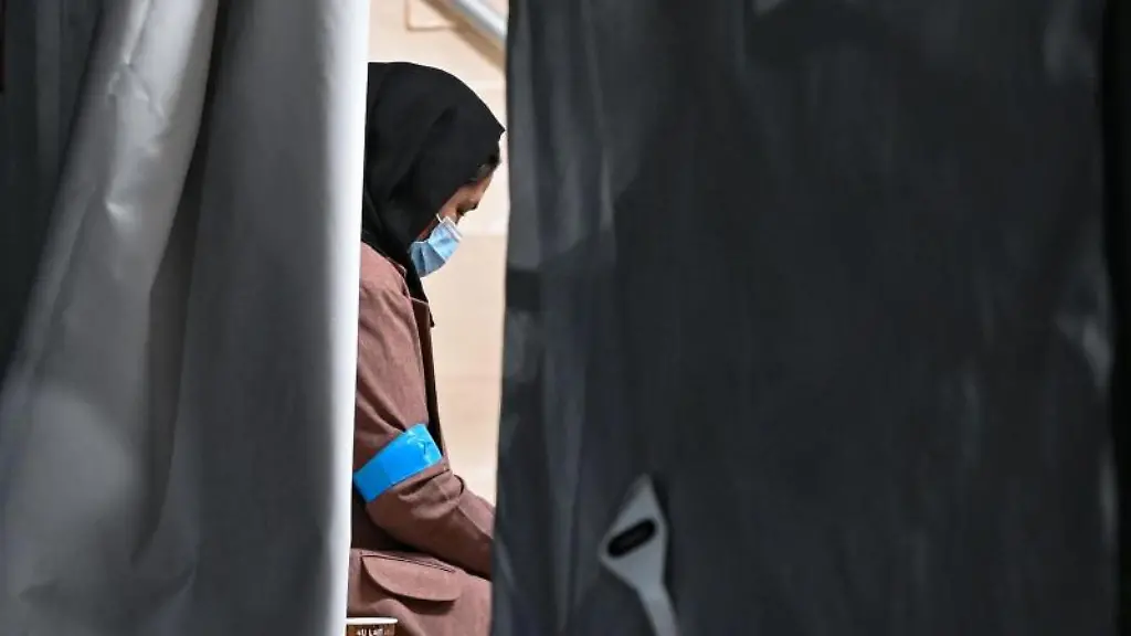 Eine-Frau-die-zusammen-mit-weiteren-Ortskraeften-aus-Afghanistan-angekommen-ist-sitzt-in-einem-Zelt