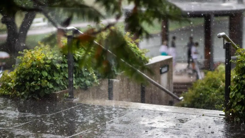 Starker-Regen-faellt-auf-eine-Terrasse-in-einem-Park
