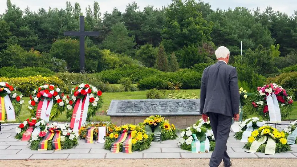 Ein-Besucher-betrachtet-nach-der-Gedenkveranstaltung-die-Kraenze