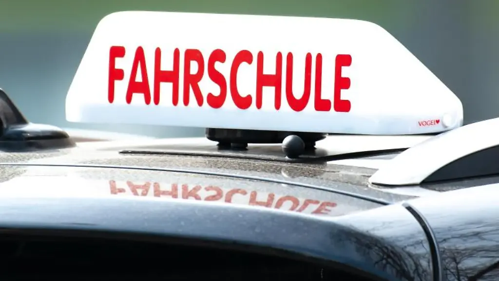 Ein-Dachschild-mit-der-Aufschrift-Fahrschule-ist-auf-einem-Fahrschulauto-befestigt