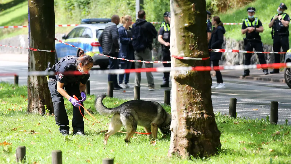 Schuesse-am-Gorch-Foch-Wall-Eine-Polizistin-ist-innerhalb-einer-Polizeiabsperrung-mit-einem-Spuerhund-im-Einsatz