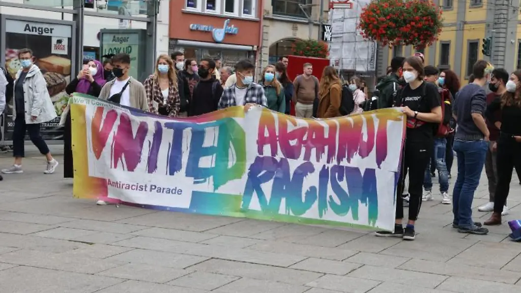 Teilnehmer-einer-Kundgebung-stehen-auf-dem-Anger