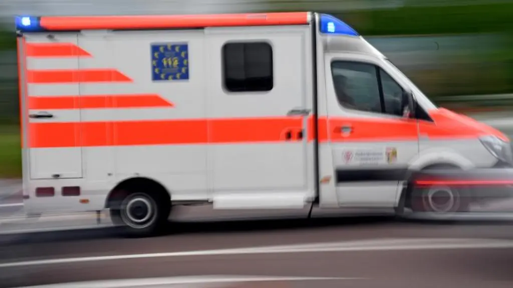Ein-Krankenwagen-faehrt-mit-Blaulicht-auf-einer-Strasse