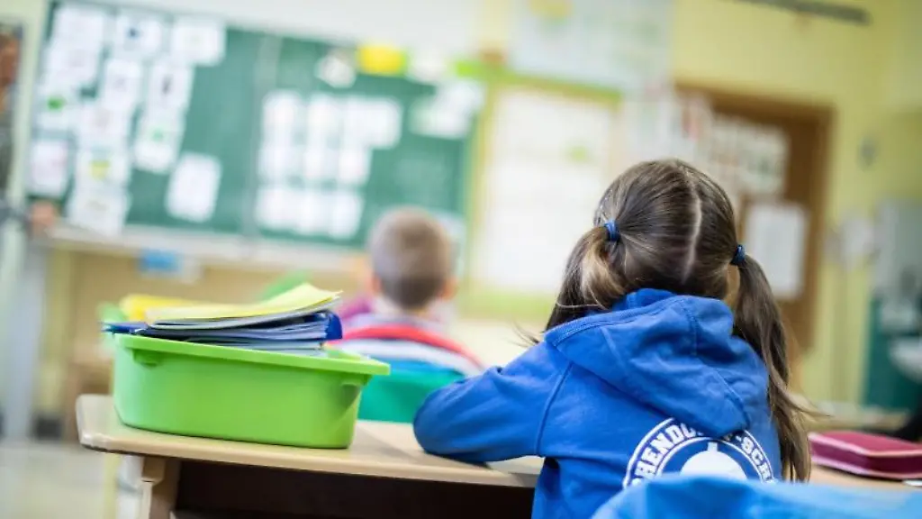 Schuelerinnen-und-Schueler-einer-Grundschule-sitzen-mit-Abstand-in-ihrem-Klassenraum