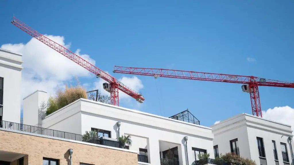 Kraene-arbeiten-hinter-neuen-Mehrfamilienhaeusern-im-Frankfurter-Europaviertel