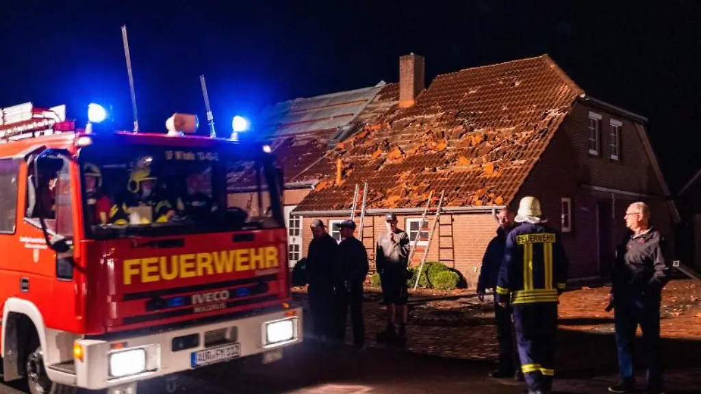 Feuerwehrleute-und-Helfer-reparieren-das-Dach-eines-beschaedigten-Hauses