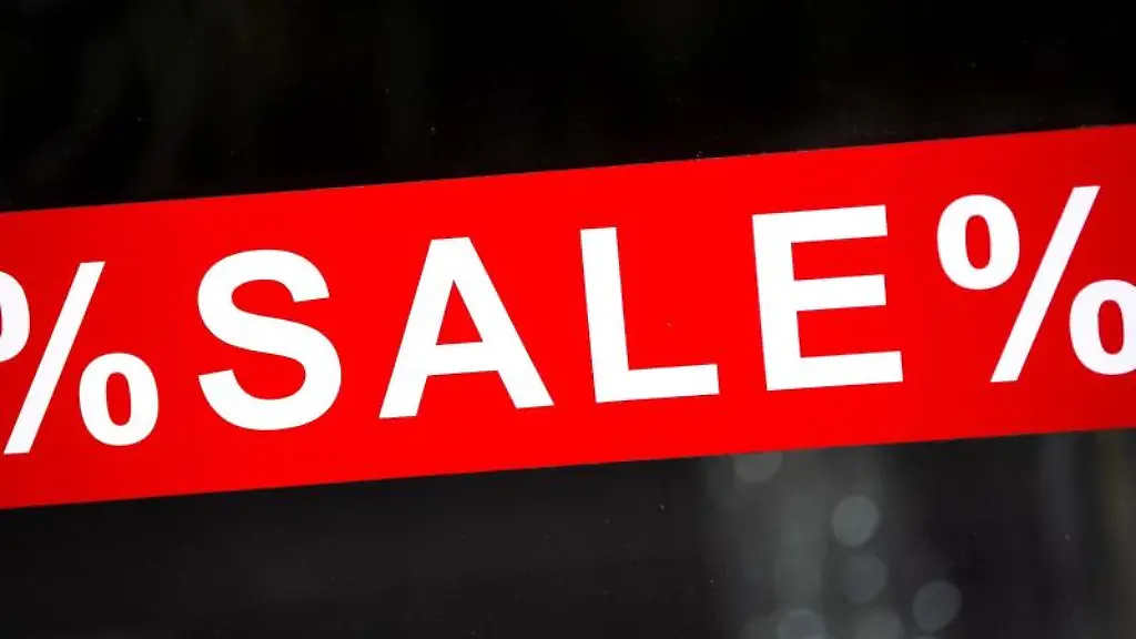 In-den-Schaufenster-von-einem-Geschaeft-haengt-eine-Werbetafel-mit-der-Aufschrift-Sale