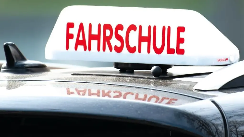 Ein-Schild-mit-der-Aufschrift-Fahrschule-ist-auf-einem-Fahrschulauto-befestigt
