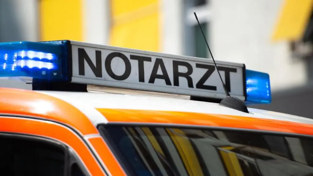 Ein-Notarztwagen-steht-mit-eingeschaltetem-Blaulicht-auf-der-Strasse