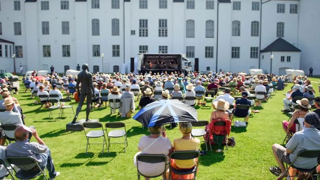 Besucher-sitzen-waehrend-eines-Konzertes-im-Rahmen-des-Schleswig-Holstein-Musik-Festivals-vor-dem-Schloss-Gottorf