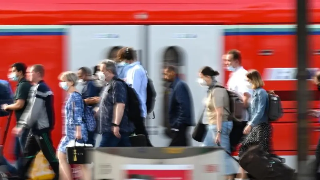 Passagiere-gehen-an-einem-Bahnhof-an-einem-Regionalzug-der-Deutschen-Bahn-vorbei