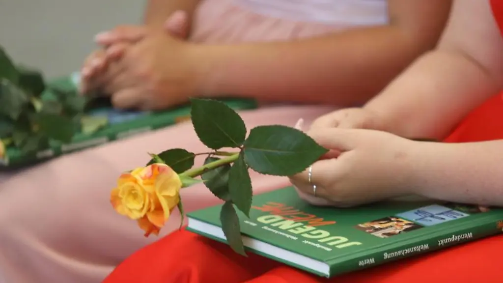 Teilnehmer-der-Jugendweihefeier-sitzen-in-einer-Halle