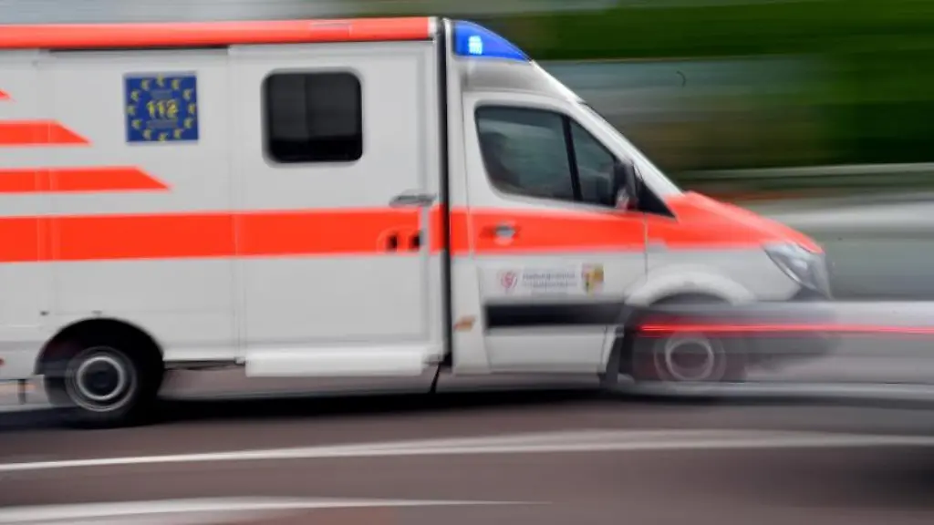 Ein-Krankenwagen-faehrt-mit-Blaulicht-auf-einer-Strasse