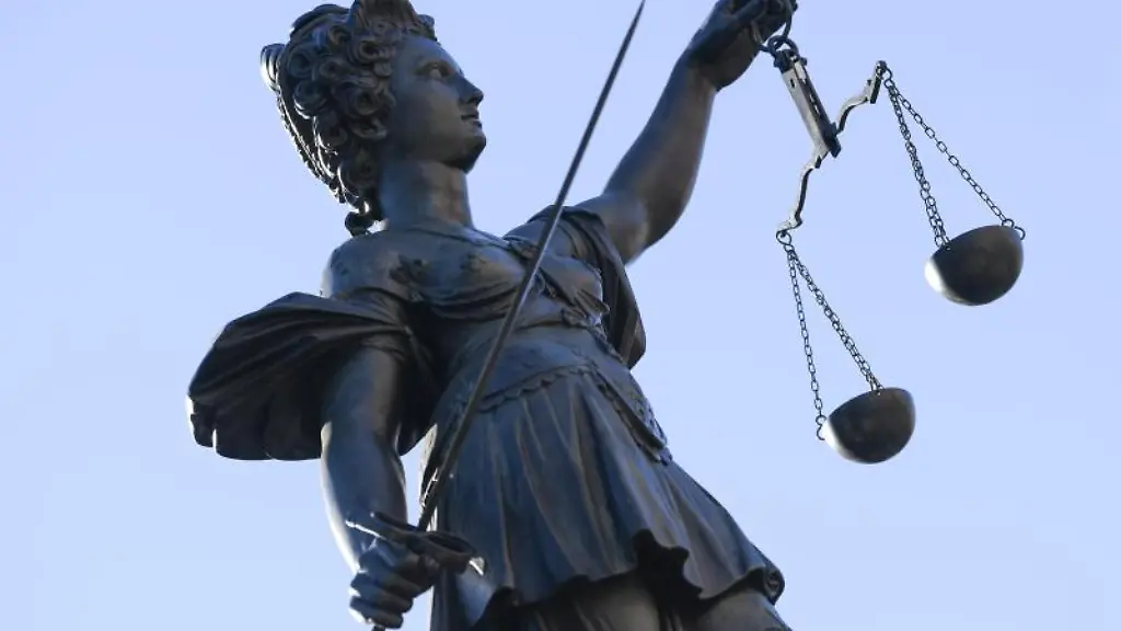 Eine-Statue-der-Justitia-steht-unter-freiem-Himmel