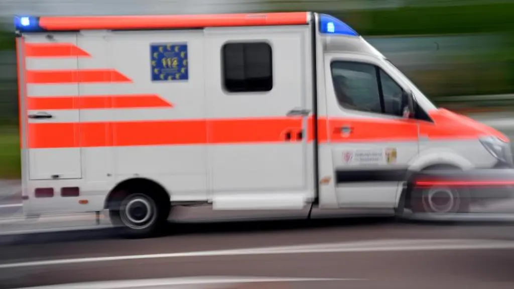 Ein-Krankenwagen-faehrt-mit-Blaulicht-auf-einer-Strasse