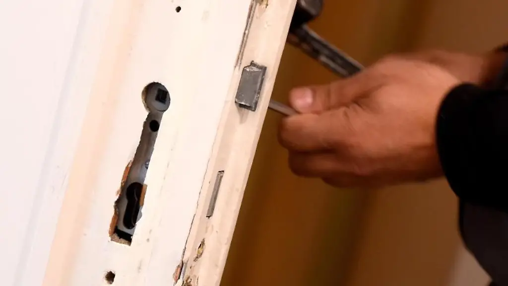 Ein-Mitarbeiter-eines-Schluesseldienstes-baut-ein-defektes-Tuerschloss-aus