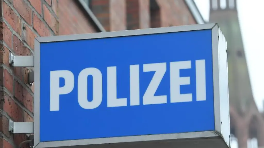 Ein-Schild-mit-dem-Schriftzug-Polizei-haengt-an-einer-Polizeiwache