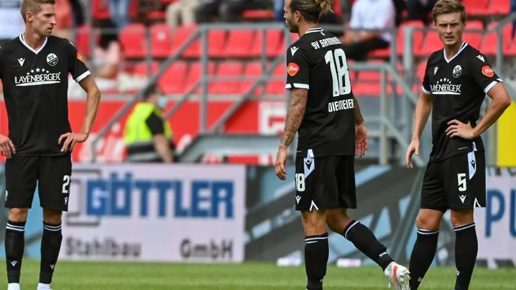 Dennis-Diekmeier-steht-mit-seinen-Mitspielern-vom-SV-Sandhausen-auf-dem-Rasen