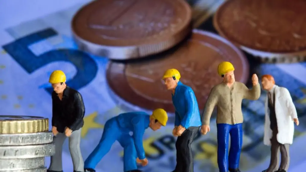 Miniatur-Figuren-stehen-vor-einem-Display-mit-einem-Foto-von-Euromuenzen-und-Geldscheinen