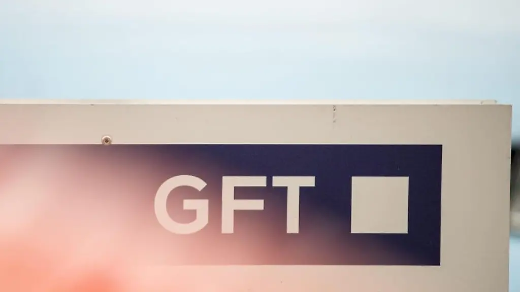 Ein-rotes-Autos-steht-auf-einem-Parkplatz-vor-einem-Schild-mit-dem-Logo-des-IT-Dienstleisters-GFT-in-Stuttgart