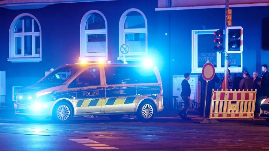 Ein-Polizeiwagen-steht-mit-Blaulicht-an-einer-Strassensperre