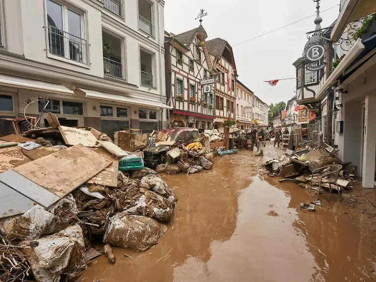 Anwohner-und-Ladeninhaber-versuchen-nach-der-verheerenden-Hochwassernacht-ihre-Haeuser-vom-Schlamm-zu-befreien