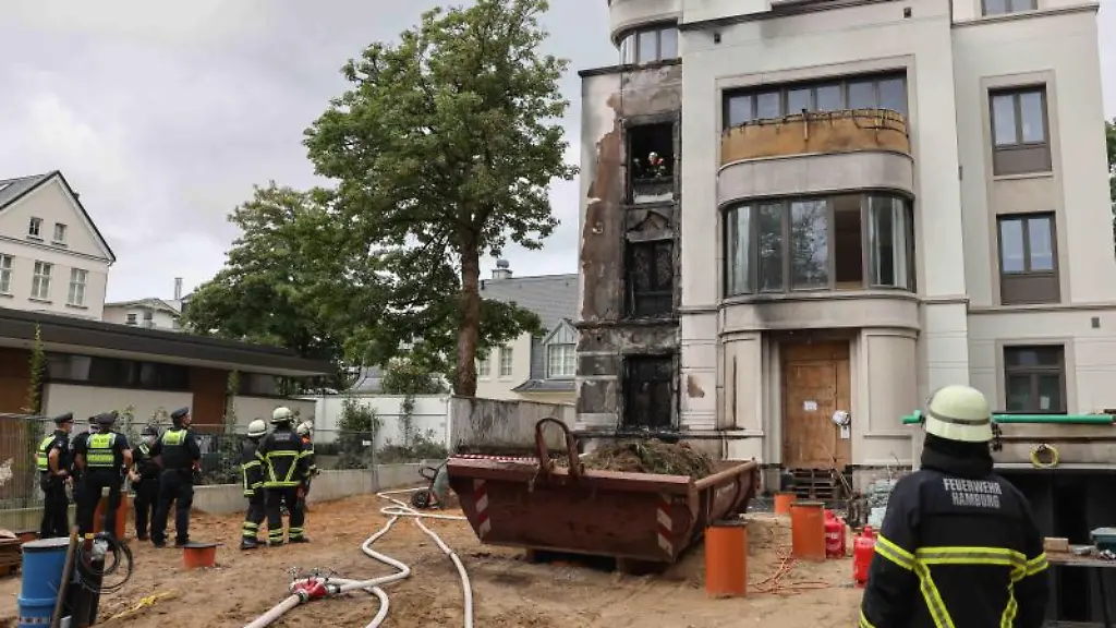 Einsatzkraefte-der-Feuerwehr-bei-Nachloescharbeiten-nach-einem-Feuer-in-Hamburg-Rotherbaum