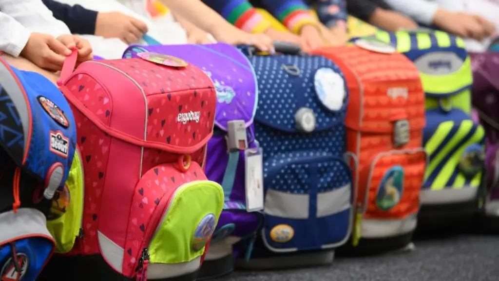 Schulanfaenger-haben-ihre-Schulranzen-vor-sich-abgestellt