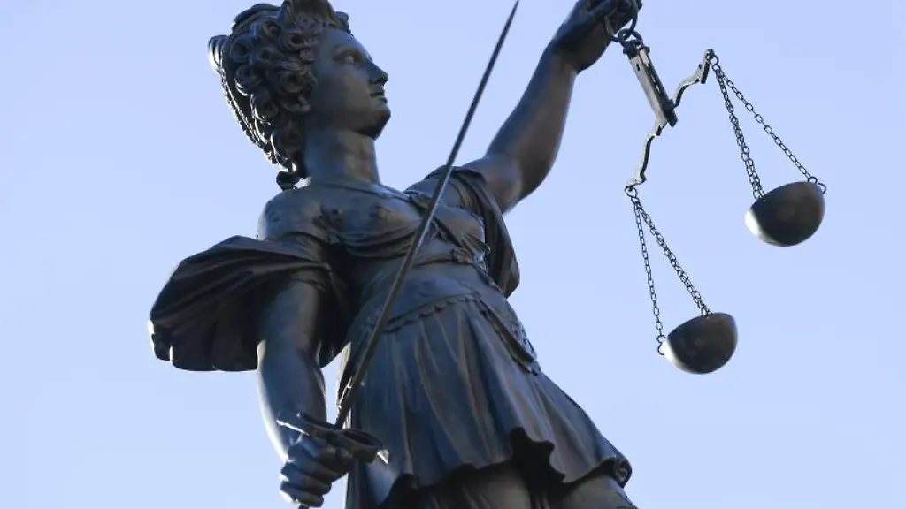 Eine-Statue-der-Justitia-steht-unter-freiem-Himmel