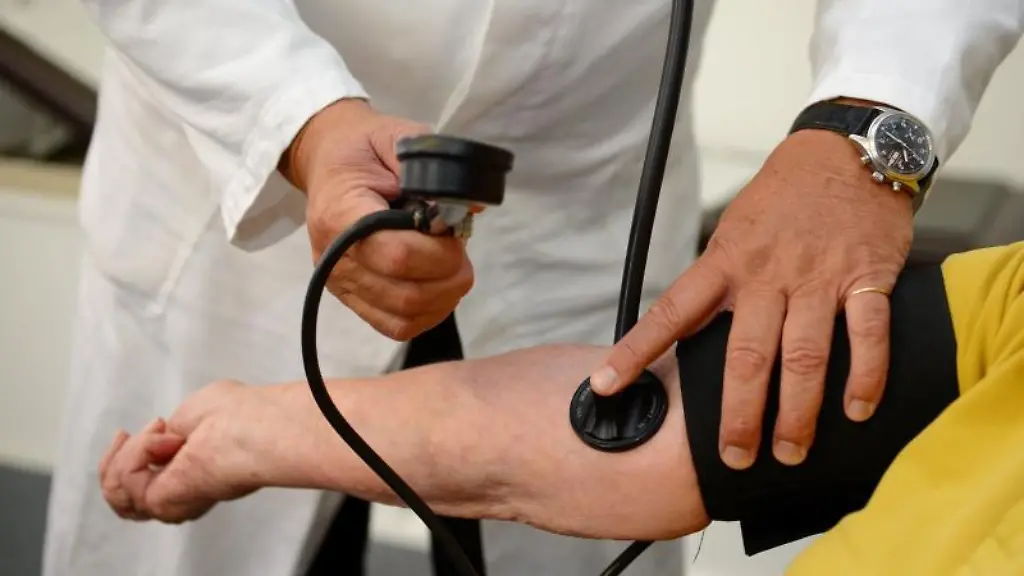 Ein-Arzt-misst-in-einer-Praxis-einer-Patientin-den-Blutdruck