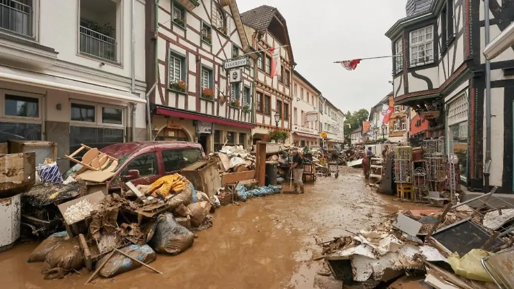 Anwohner-und-Ladeninhaber-versuchen-ihre-Haeuser-vom-Schlamm-zu-befreien