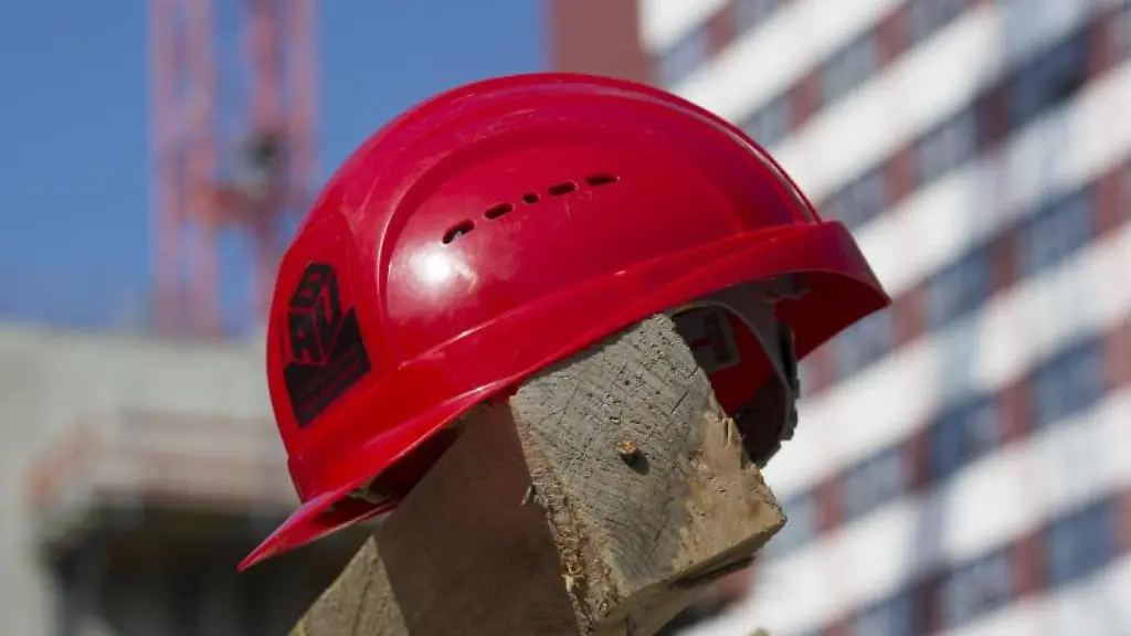 Ein-Bauhelm-liegt-auf-einem-Holzbalken