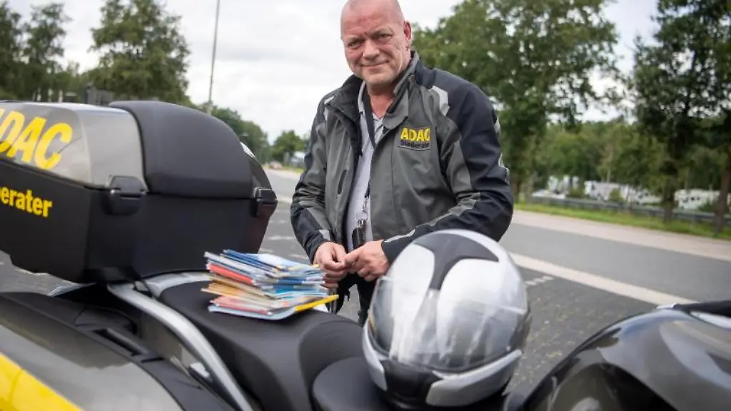 Roger-Jahn-ADAC-Stauberater-steht-auf-einer-Raststaette-neben-seinem-Motorrad