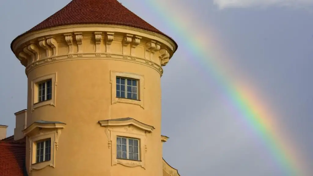 Ein-Regenbogen-ist-nach-einem-heftigen-Regenguss-hinter-Schloss-Rheinsberg-am-dunklen-Himmel-zu-sehen