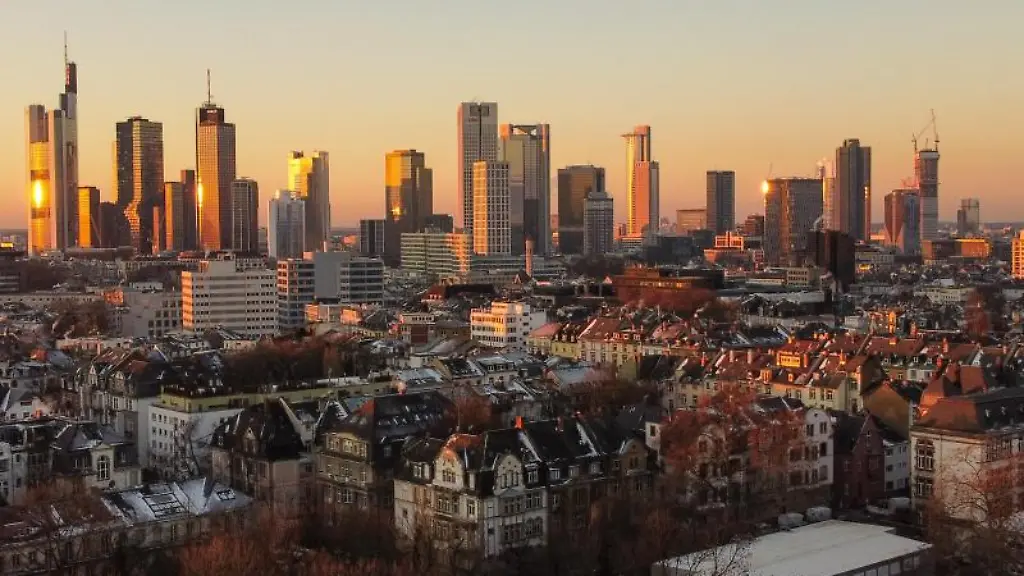 Das-Licht-der-aufgehenden-Sonne-streift-die-Hochhaeuser-der-Skyline-Frankfurts