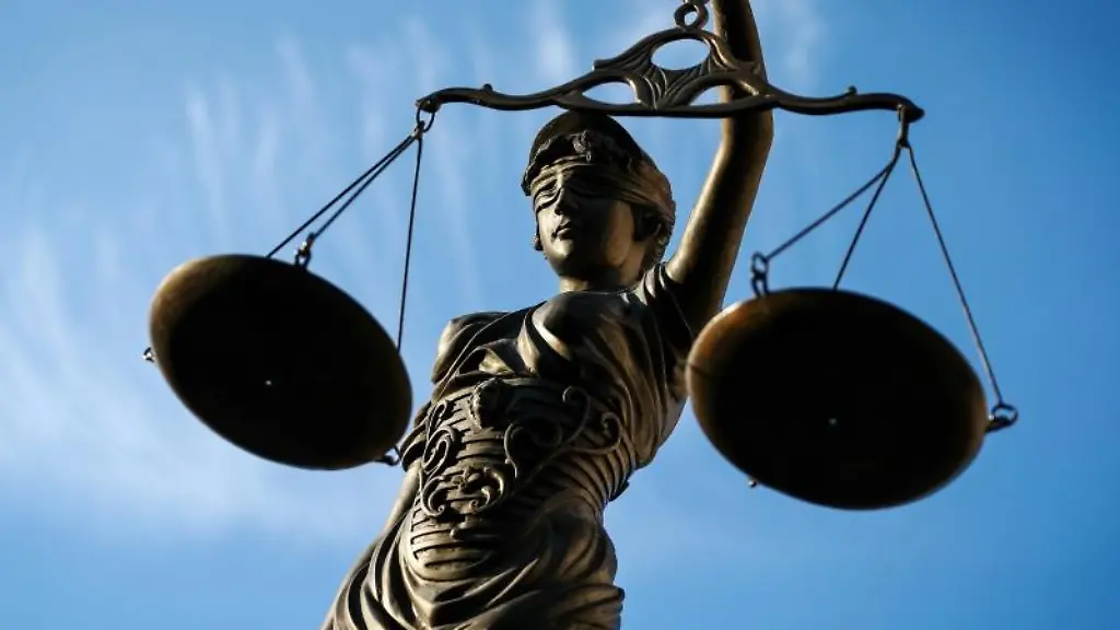 Eine-Statue-der-Justitia-haelt-eine-Waage-in-ihrer-Hand