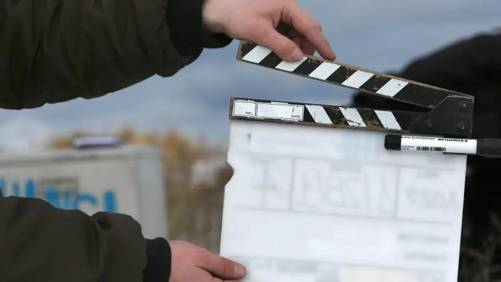 Ein-Film-Team-Mitarbeiter-haelt-eine-Filmklappe
