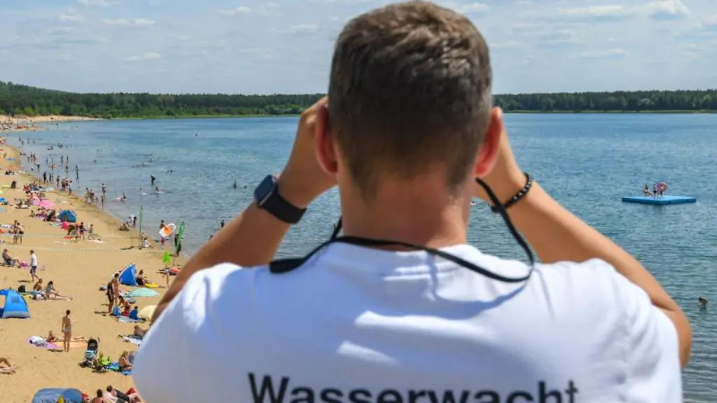 Ein-Rettungsschwimmer-vom-Deutschen-Roten-Kreuz-DRK-beobachtet-die-Badegaeste-im-Wasser-eines-Sees
