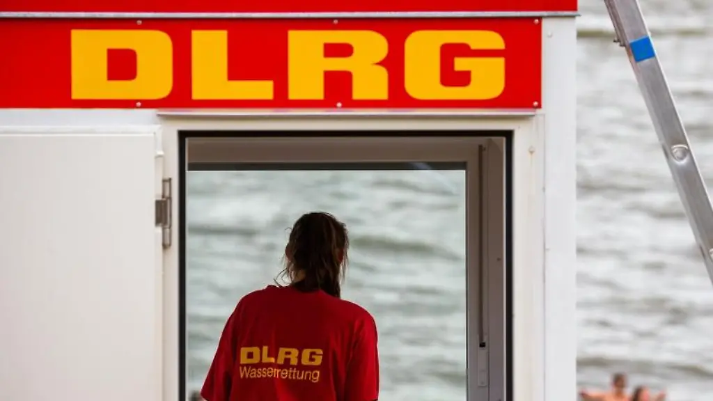 Eine-Rettungsschwimmerin-der-DLRG-steht-vor-dem-Fenster-eines-Wachturms