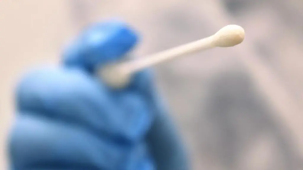 Ein-Arzt-haelt-einen-Tupfer-mit-dem-ein-Abstrich-fuer-einen-Coronatest-gemacht-wird