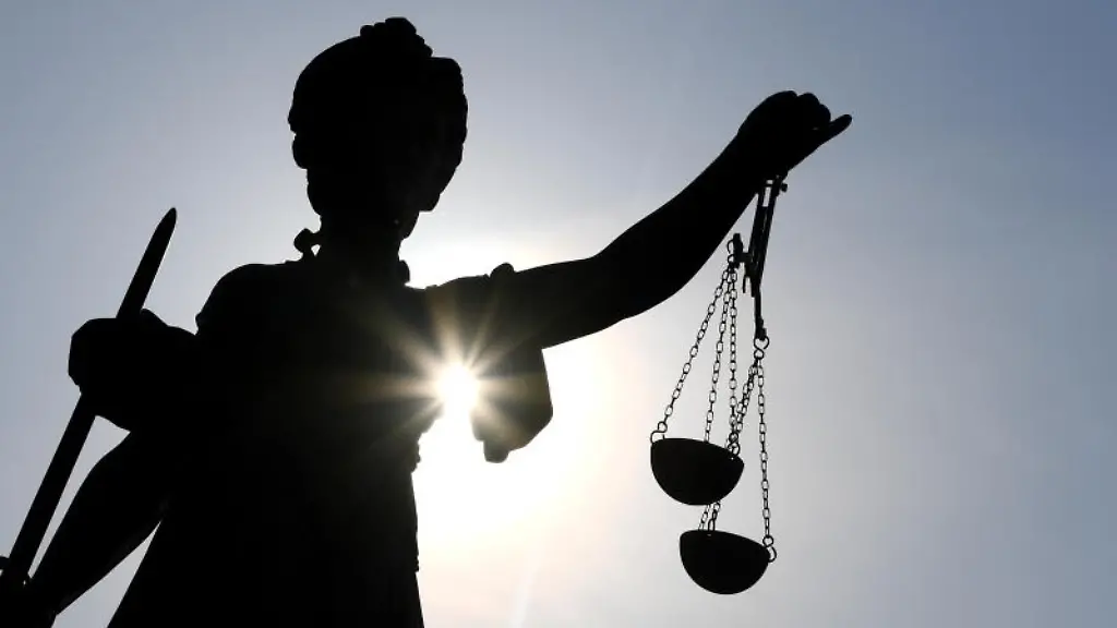 Eine-Statue-der-Justitia-mit-einer-Waage-und-einem-Schwert-in-ihren-Haenden