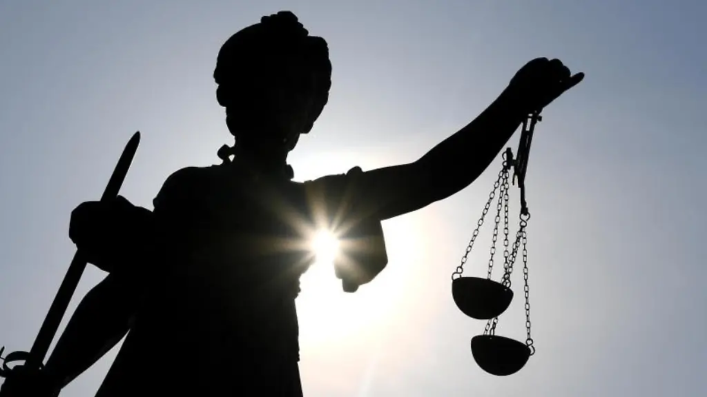 Die-Statue-der-Justitia-steht-im-Gegenlicht-der-Sonne