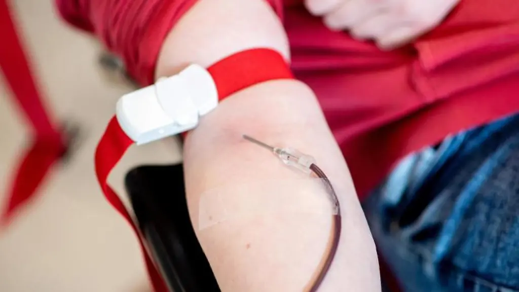 Blut-laeuft-waehrend-einer-Blutspende-vom-Arm-einer-Spenderin-durch-eine-Nadel-in-einen-Beutel