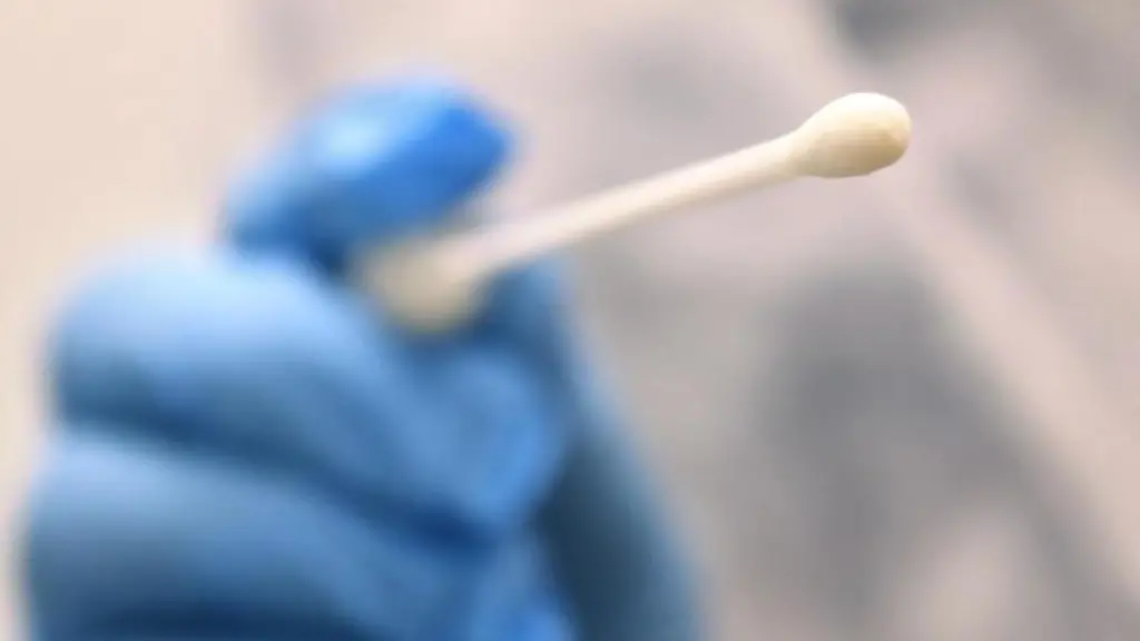 Ein-Arzt-haelt-einen-Tupfer-mit-dem-ein-Abstrich-fuer-einen-Coronatest-gemacht-wird