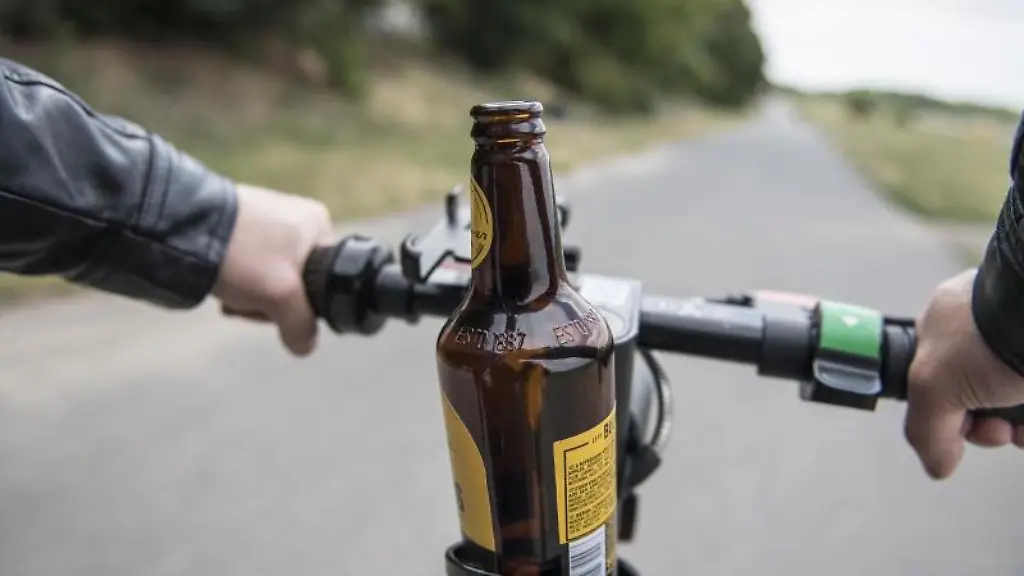 Eine-Bierflasche-steht-auf-einem-E-Scooter