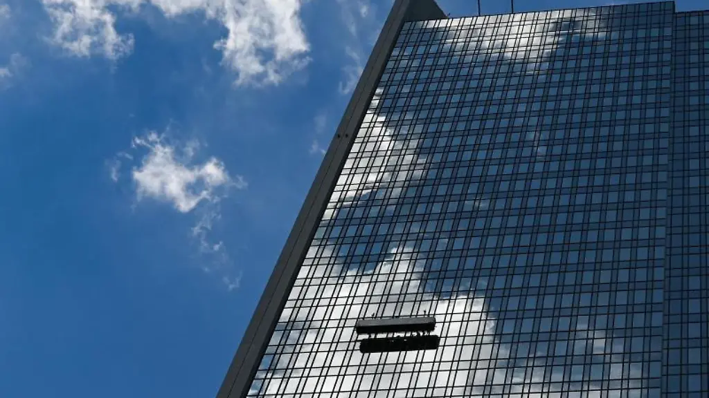 Waehrend-Fensterputzer-arbeiten-spiegelt-sich-der-Wolkenhimmel-in-der-Fassade